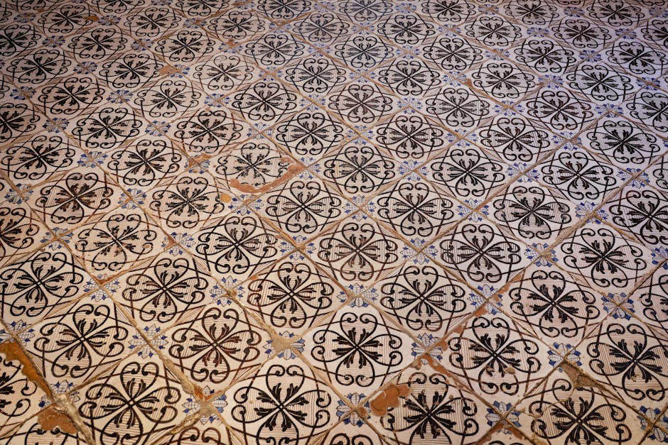 Close-up view of a worn, beige-colored wooden floor with visible scratches, scuff marks, and paint splatters in a residential interior, likely on the ground floor of a house in Lillie Road during a ho