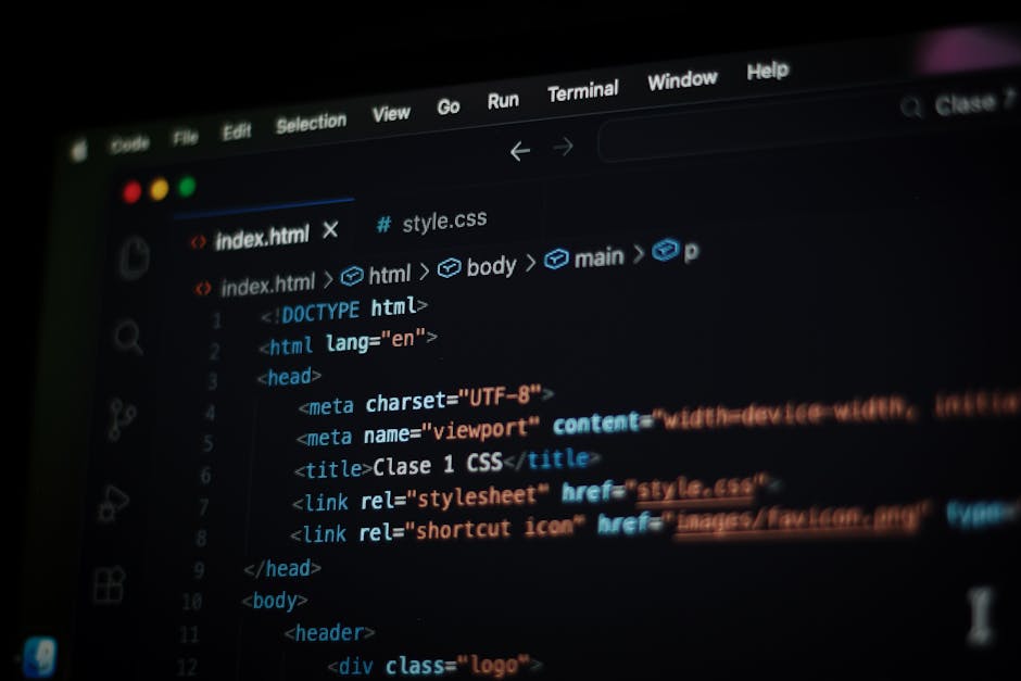 Close-up view of a MacBook Pro laptop displaying a webpage with code snippets, situated on a desk. The screen shows a coding editor with HTML and Ruby code, featuring colorful syntax highlighting, wor